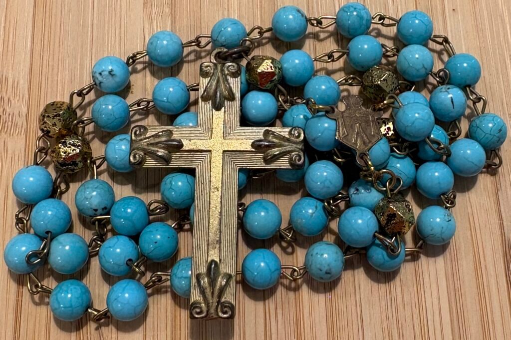 Rosario artesanal de cuentas turquesa con cruz ornamentada y detalles dorados